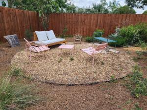 a backyard with a couch and chairs and a fence at GardenHouse @AudubonPark Sleeps 8 in Orlando