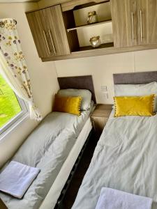 two beds in a small room with a window at The Ascot by North Shacks in Slaley