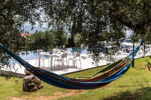 a blue hammock hanging from a tree next to a pool at Appartamento La Mignola in Campiglia Marittima