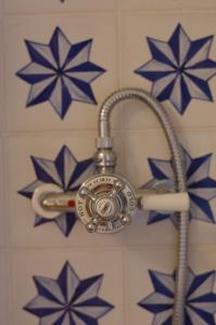 un soffione doccia con tubo appeso a un muro di Alpenchalet Waldl - la Lepre a Palù del Fersina