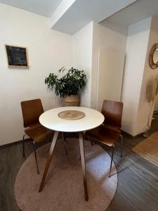 a table and chairs in a room with a plant at Graz City Centre Apartment 12 in Graz