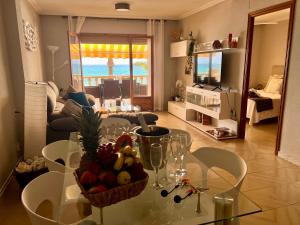 een woonkamer met een tafel met een fruitschaal erop bij Apartamento frente al mar en El Campello in El Campello