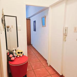 a hallway with a red table with stuffed animals on it at Back to the 80s in Cape Town