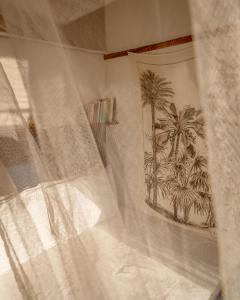 a white curtain with a picture of palm trees at La Luciole Ecolodge in Paraty