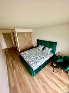 1 dormitorio con 1 cama grande y cabecero verde en Sidi Rahal en Sidi Rahal