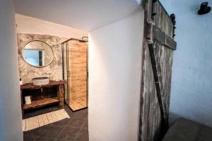 een badkamer met een houten deur en een spiegel bij Hamerská chaloupka in Hlinsko