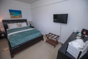 um quarto com uma cama e uma televisão de ecrã plano em El Velero 203 en Boquerón em Boqueron
