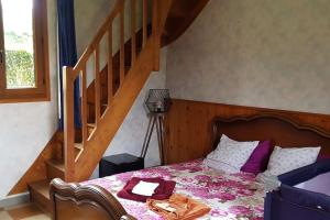 a bedroom with a bed and a staircase at Grande maison normande autosuffisante en énergie in Ticheville