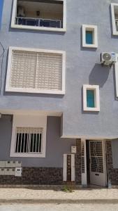 ein blaues Gebäude mit einem Fenster und einer Tür in der Unterkunft Apartamento in Saidia 