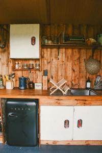 a kitchen with a counter with a sink and a stove at Infinite Skies Tipi's in Heydon