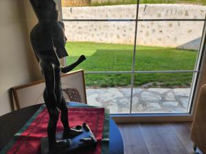 普里什蒂納的住宿－Shtepia e Malit，窗前桌子上的男人的雕像
