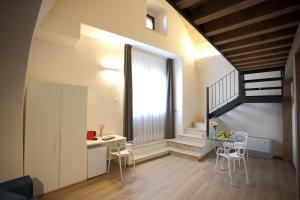 een woonkamer met een trap en een tafel en stoelen bij Casa Nera GuestHouse in Montescaglioso