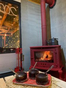 una estufa roja con algo de comida en una mesa en eşsiz doğa manzarasında jakuzi keyfi sunan dağ evi, en Gölcük