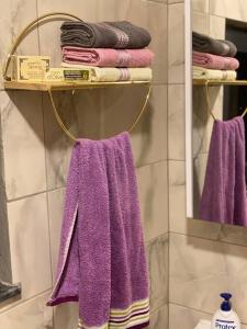 a towel rack with purple towels on it in a bathroom at eşsiz doğa manzarasında jakuzi keyfi sunan dağ evi in Gölcük