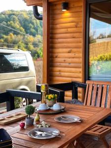 una mesa de madera con platos en el porche en eşsiz doğa manzarasında jakuzi keyfi sunan dağ evi, en Gölcük