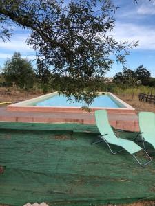 2 sillas de jardín sentadas junto a una piscina en Forest Domes, en Setúbal