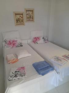 Una cama blanca con almohadas y toallas. en Annas seaside apartment, en Perea