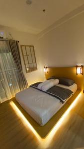 a bedroom with a bed with lights on it at Japanese Zen Room Citra Plaza Nagoya Batam in Nagoya