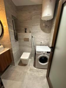 a bathroom with a toilet and a washing machine at Lucas holiday home in Tal-Pietà