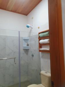 a bathroom with a shower and a toilet with a glass door at Suite amoblada en Santa Cruz in Puerto Ayora