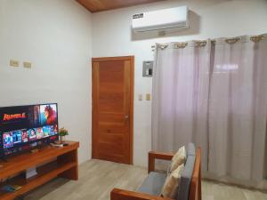 a living room with a flat screen tv and a window at Suite amoblada en Santa Cruz in Puerto Ayora