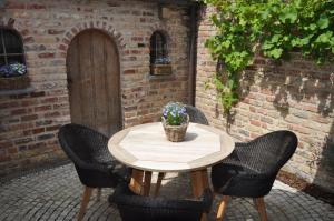 a wooden table with chairs and a potted plant on a patio at Vakantiehuis 't Verloren Schaap Damme in Damme