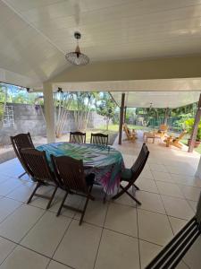 a patio with a table and chairs on a porch at Fare Moehani in Paea