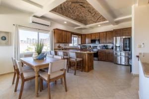 a kitchen with wooden cabinets and a table and chairs at Sandy Beach Costa Diamante E15 House Game Room Dog Friendly in Puerto Peñasco