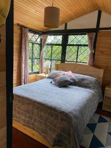 - une chambre avec un lit dans une pièce dotée de fenêtres dans l'établissement Chalet Guata & Exclusividad & Ubicación estratégica, à Sesquilé