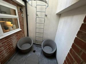 Un baño con dos inodoros al lado de una pared de ladrillo. en Two Bedroom House In Kilburn, en Londres 7 fotos más
