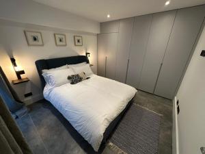 Two Bedroom House In Kilburn في لندن: غرفة نوم بسرير ابيض يوجد عليها حيوان محشو