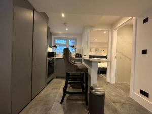 una cocina con taburete en el medio de una habitación en Two Bedroom House In Kilburn, en Londres