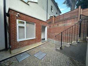 a brick building with a staircase and a window at Two Bedroom House In Kilburn in London