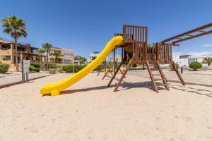 a playground with a yellow slide in the sand at Sandy Beach Costa Diamante E15 House Game Room Dog Friendly in Puerto Peñasco