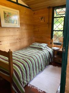 a bedroom with a bed in a log cabin at Chalet Guata & Exclusividad & Ubicación estratégica in Sesquilé