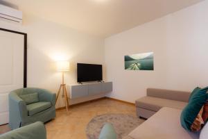 - un salon avec un canapé et une télévision dans l'établissement Porta Torre Como Apartment - By Relais Di Giada, à Côme