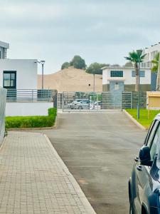un parcheggio con auto parcheggiate di fronte a un edificio di Sidi Rahal a Sidi Rahal