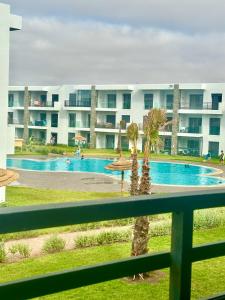 a view from the balcony of a hotel with a swimming pool at Appartement Cozy avec piscine in Sidi Rahal