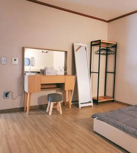 Schlafzimmer mit einem Schreibtisch, einem Bett und einem Spiegel in der Unterkunft Peace and Quiet in Seoul