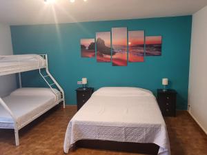 - une chambre avec 2 lits et un mur bleu dans l'établissement VT y HT arrizabalaga rural montaña, à Bermeo