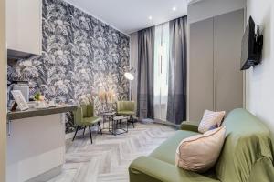 ein Wohnzimmer mit einem grünen Sofa und einem Tisch in der Unterkunft Hanky Suite in Rom