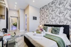 1 dormitorio con 1 cama grande y papel pintado con motivos florales en Hanky Suite, en Roma