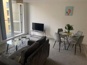 曼徹斯特的住宿－Beautiful Manchester 2 bedroom apartment，带沙发、桌子和电视的客厅