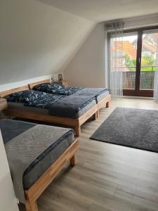 een slaapkamer met 3 bedden en een raam bij FMA Ferienwohnung Alfdorf in Alfdorf