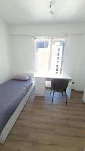 Schlafzimmer mit einem Bett, einem Schreibtisch und einem Fenster in der Unterkunft 37th Floor - SkyView Oasis - C in Skopje