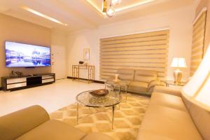een woonkamer met een bank en een tv bij Kumasi Luxury Apartments @ The Fairview in Kumasi