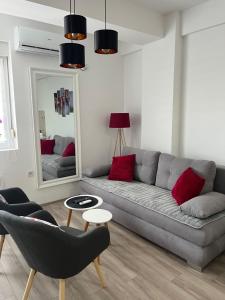uma sala de estar com um sofá cinzento e um espelho em R Lux Apartman Jagodina Akva Park em Jagodina