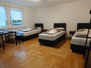 a room with three beds and a table and a desk at 2BR Apartment, Parking, Wi-Fi, TV in Berlin Karow in Berlin