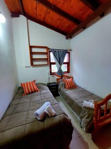 a bedroom with two beds and a wooden ceiling at CASA los ciruelos in El Bolsón