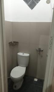 a bathroom with a white toilet in a stall at Hotel Srikandi Baru in Yogyakarta
